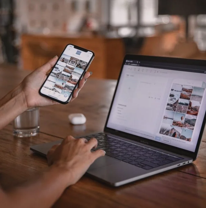 Freelance mobile app developer testing a smartphone application connected to a laptop workspace